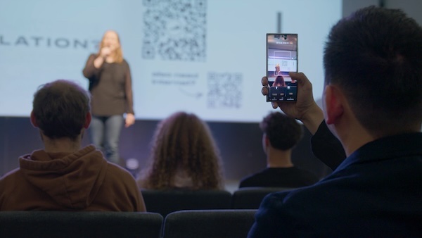 Someone scanning a Breeze QR code on a screen during a service